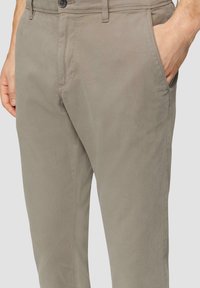 Chino en mélange de coton gris clair avec une texture lisse, une coupe droite, deux poches latérales et une fermeture à bouton à la taille.