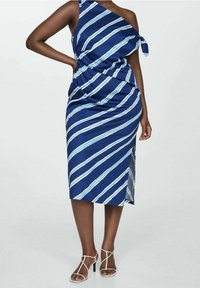 Robe rayée bleu et blanc avec un design asymétrique à une épaule, détail noué, et longueur midi, confectionnée dans un tissu doux. Soulignée d'une fente latérale.