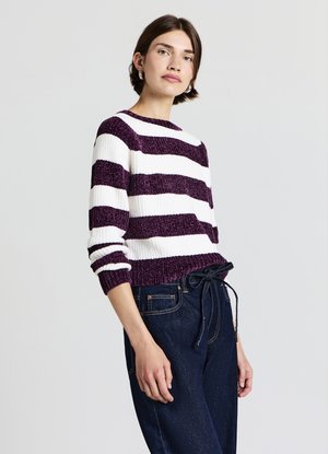 Striped sweater with thick white and dark purple yarn; crew neckline, ribbed cuffs, and hem. Paired with dark denim pants featuring a tie waist.