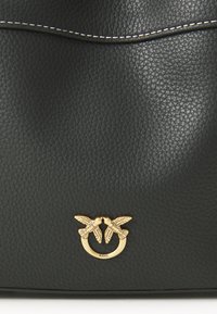 Μαύρη δερμάτινη τσάντα χειρός με υφή και χρυσές λεπτομέρειες σε σχήμα δύο πουλιών. Περιλαμβάνει λευκές ραφές.