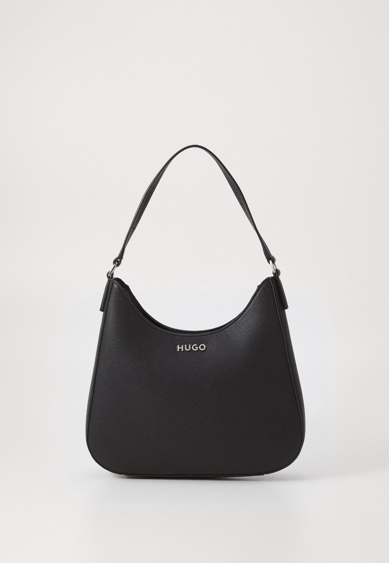 Černá kožená taška přes rameno s zakřiveným vrškem, krátkým popruhem a stříbrným logem "HUGO" umístěným uprostřed na přední straně.