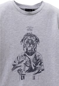 Graues Baumwoll-T-Shirt mit einem Grafikdesign eines Hundes in einem Rugby-Uniform, der einen Rugbyball hält. Der Text darüber enthält "IKKS PLAYER" und verwandte Details.