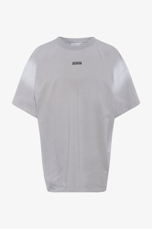 Jasnoszara koszulka z krótkim rękawem, z okrągłym dekoltem, luźny krój i małym czarnym logo z przodu. Gładki materiał bawełniany.