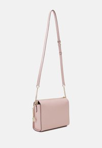 Mała różowa torba crossbody o gładkiej fakturze, z akcentami ze złotego łańcucha i regulowanym paskiem; prostokątny kształt z zapięciem na zamek.