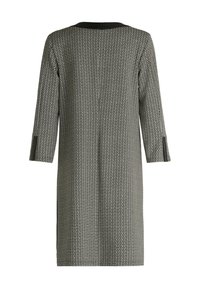 Zwart-wit jurk met patroon, driekwart mouwen, ronde halslijn, rechte snit en een lichte glans op de stof.