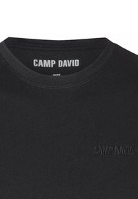 Zwarte katoenen t-shirt met een ronde halslijn, voorzien van een reliëf "CAMP DAVID" logo. Soepele textuur, basaal ontwerp zonder patronen of accenten.