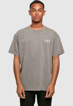 Grå oversized t-shirt lavet af blødt, tekstureret stof. Har en rund hals og trykt "LIFE" detalje på fronten.