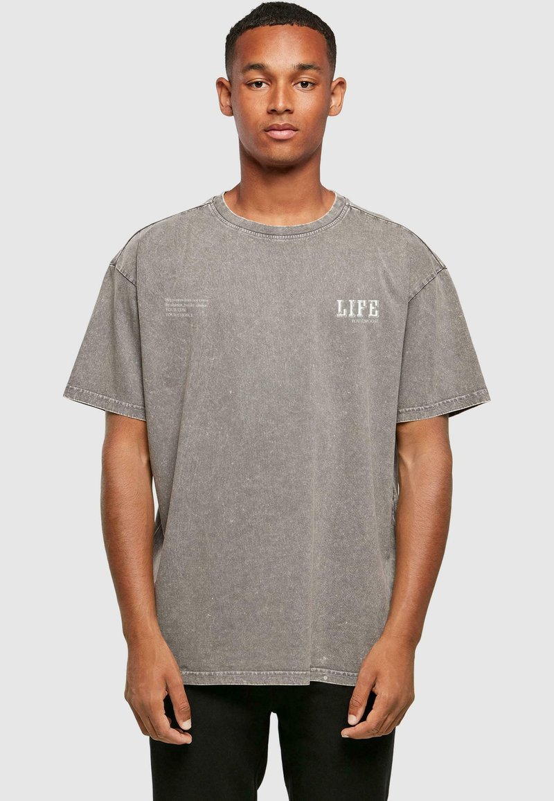 Grå oversized t-shirt lavet af blødt, tekstureret stof. Har en rund hals og trykt "LIFE" detalje på fronten.