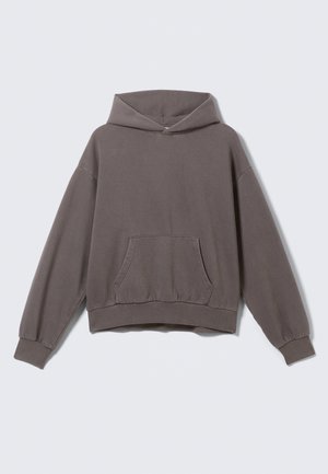 Oversized, brown hoodie with a front pocket, ribbed hem, and cuffs; made from soft, textured fabric and features a drawstring hood.