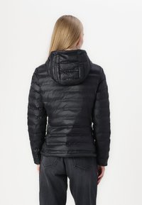Černá péřová bunda s kapucí, která má prošívaný design a hladký povrch. Zadní část má přizpůsobený tvar s elastickými manžetami.