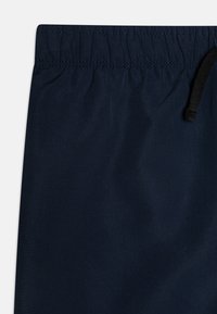Bañador navy con cinturilla elástica, cordón ajustable y una tela suave y ligera. Sin patrones visibles ni elementos metálicos.