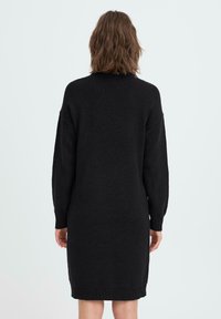 Svart strikket kjole med lange ermer, ribbede mansjetter og nederkant, og en avslappet passform, med en jevn tekstur og mellomlang design.