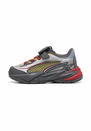 Grauer, roter und gelber Sportschuh mit dicker Sohle, Mesh-Details, roten Schnürsenkeln und schwarzem Klettverschluss auf weißem Hintergrund.