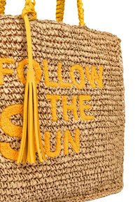 Bag in paglia intrecciata con frange gialle, che presenta la frase "SEGUITA IL SOLE" ricamata in giallo sul davanti.