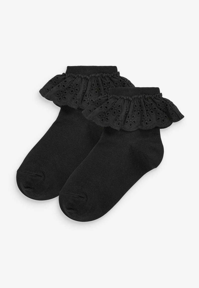 Chaussettes de cheville noires avec une finition en dentelle froncée. Le matériau est un coton doux avec des découpes florales dans la dentelle. Texture lisse, design simple.