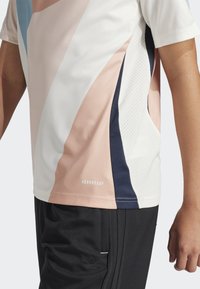 Korte mouwen sportshirt met een mix van pastelkleuren, ademende textuur en geometrisch ontwerp met 'AEROREADY' branding aan de zoom.