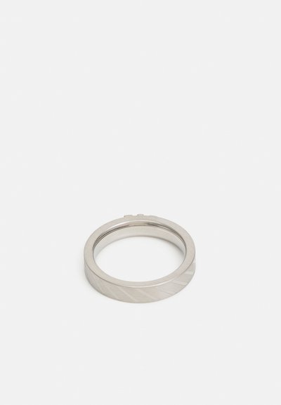 Silver metal ring with a flat band, featuring diagonal etched lines and a smooth, polished inner surface.