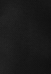 Tejido negro con una textura suave y un patrón de tejido diagonal, de color uniforme sin acentos o adornos visibles.