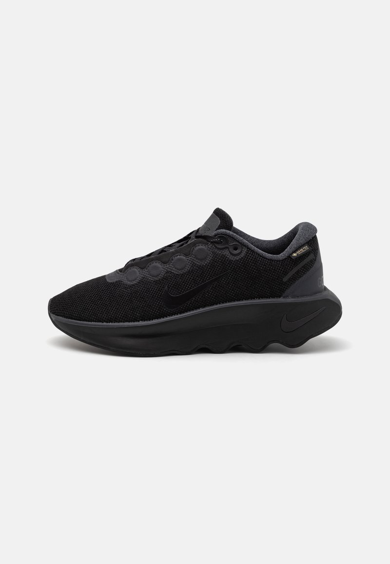 Svarte Nike-sneakers med overdel i teksturert stoff, distinkte runde snøringer og tykk svart gummisåle. Har polstret krage.