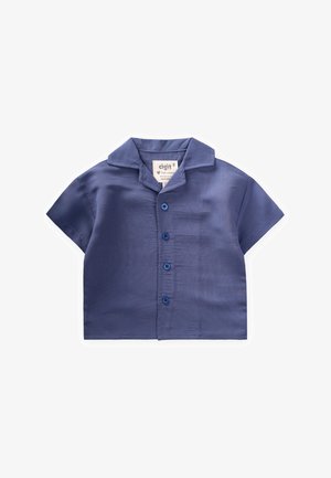 Mēju ar īsām piedurknēm, tumši zila krāsā, ar apkaklīti, kurai ir pogājamā priekšpuse un birka, uz kuras norādīts zīmola nosaukums.