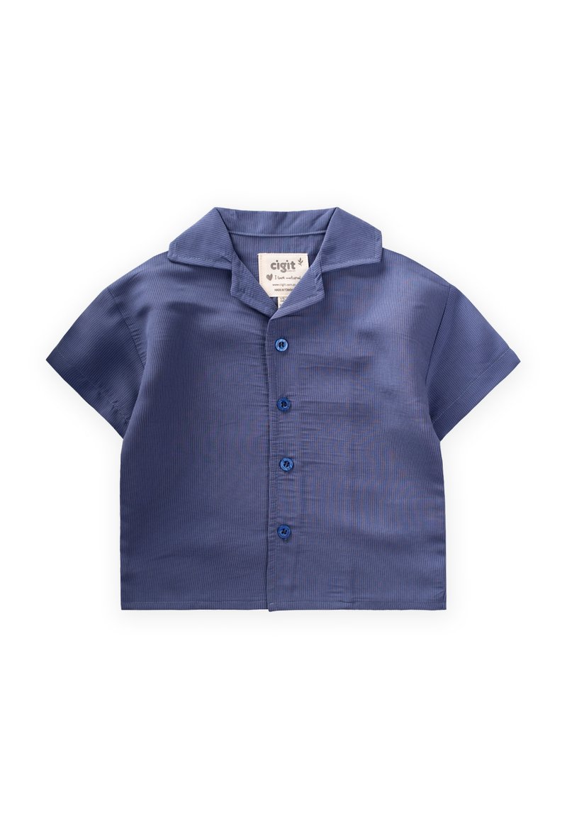 Mēju ar īsām piedurknēm, tumši zila krāsā, ar apkaklīti, kurai ir pogājamā priekšpuse un birka, uz kuras norādīts zīmola nosaukums.