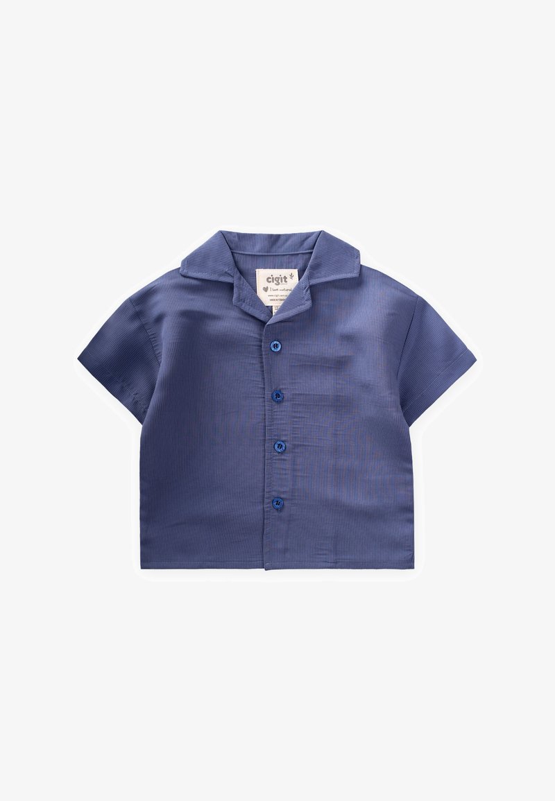 Mēju ar īsām piedurknēm, tumši zila krāsā, ar apkaklīti, kurai ir pogājamā priekšpuse un birka, uz kuras norādīts zīmola nosaukums.