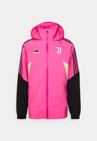 Rosa vindjakke med hætte, sorte ærmer og gule detaljer. Har Adidas og Juventus logoer, frontlynlås og stribet design.