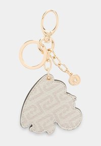 Nøglekam med et struktureret bladformet vedhæng i lys beige, der har et subtilt logo-mønster, hardware i guldfarve og en dekorativ kædelforbindelse.