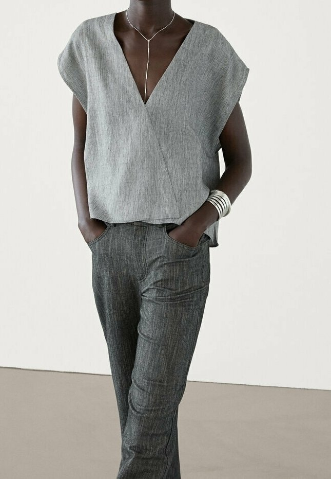 Gray linen, short-sleeved wrap top paired with gray textured pants. Simple design, v-neckline, and minimalistic silver jewelry accents.