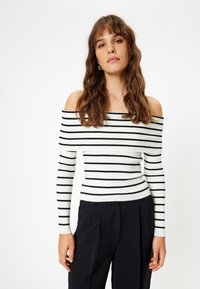 Top a strisce bianco e nero in materiale a coste, con maniche lunghe e silhouette aderente.