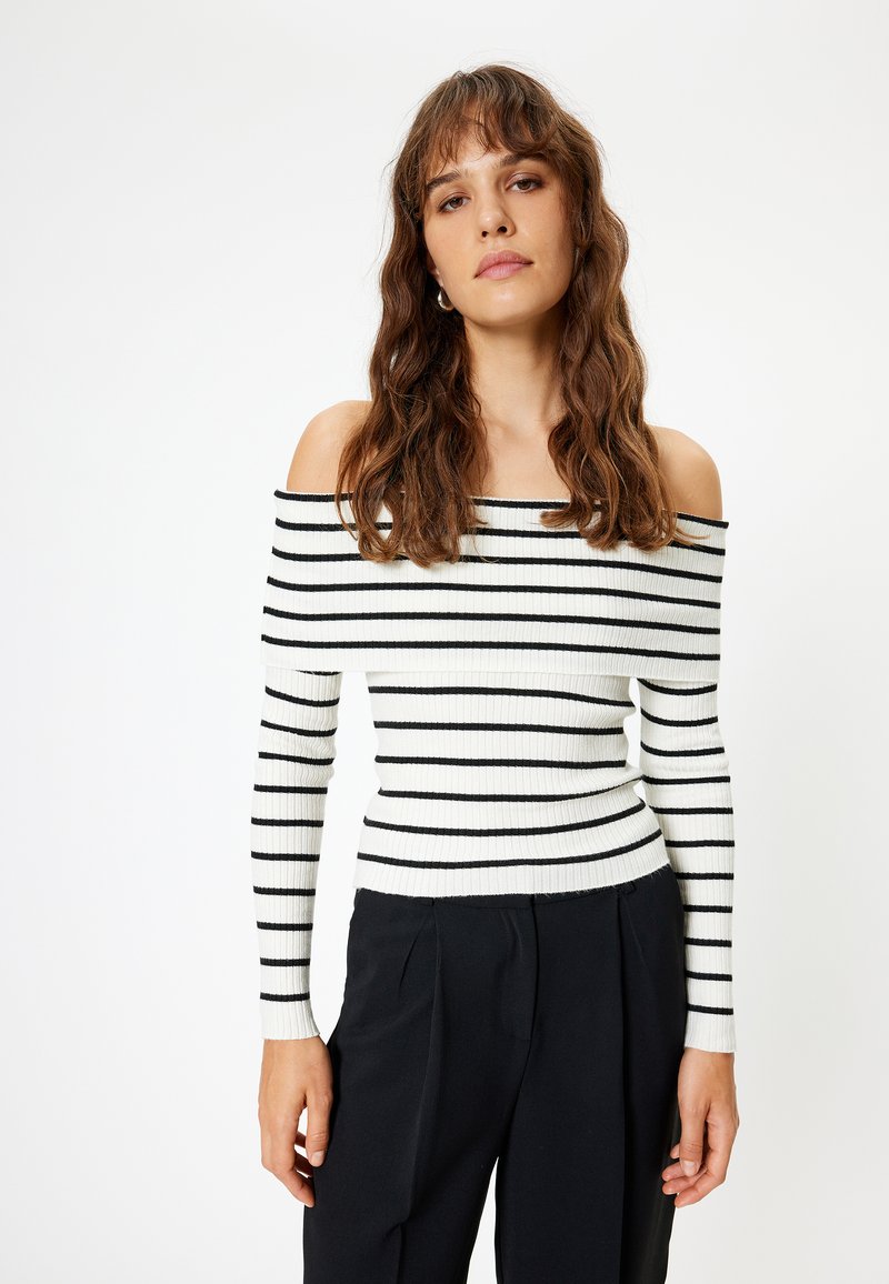 Top a strisce bianco e nero in materiale a coste, con maniche lunghe e silhouette aderente.
