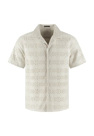 Kortærmet beige skjorte med knapper, åben krave og geometrisk mønster af firkantede udskæringer over hele stoffet.