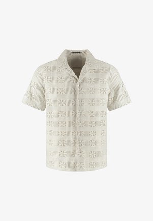 Camicia beige a maniche corte con bottoni davanti, colletto aperto e motivo a quadrati geometrici traforati su tutto il tessuto.