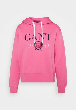 Sweat à capuche rose avec une coupe décontractée, capuche avec cordon de serrage et poignets côtelés. Présente un logo GANT bleu marine et une impression 1949 au centre. Texture de tissu douce.