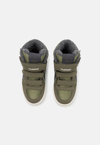 Par de zapatillas altas para niños en verde oliva con forro de felpa gris, tres correas de Velcro y suelas blancas, vistas desde arriba.