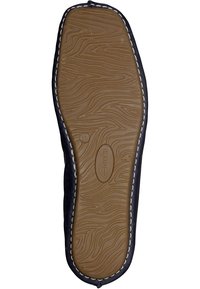Semelle d'une chaussure, présentant une surface en caoutchouc marron texturé avec un motif en zigzag, bordée de tissu noir et de couture blanche.