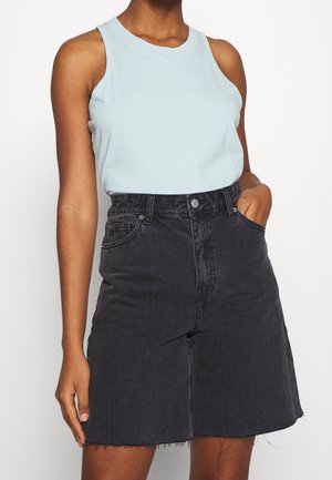 Jasnoniebieska bluzka bez rękawów w połączeniu z czarną spódnicą dżinsową z postrzępionym dołem i przednimi kieszeniami. Prosty design o luźnym kroju.