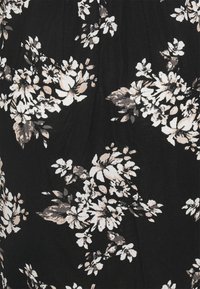 Svart tyg med ett blommönster av vita och beige blommor, som visar varierade former och storlekar, med en mjuk, texturerad yta.