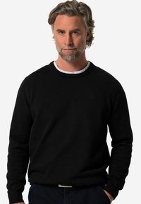 Mustapaita, jossa on pyöreä kaula-aukko ja pitkät hihat. Tasainen pinta, ribbaatut hihansuut ja helma, etupuolella on huomaamaton logo.