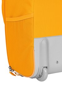 Rolling luggage with an orange, textured fabric exterior and a gray base. Includes a side pocket with a zip, and a plastic wheel for mobility.