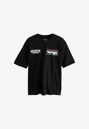 Schwarzes Baumwoll-T-Shirt mit dem "Stranger Things"-Logo und Grafiken des Radiosenders in Weiß und Rot. Kurze Ärmel mit rundem Halsausschnitt.