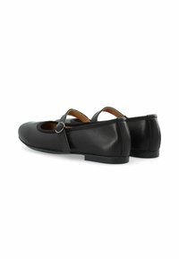 Black leather Mary Jane shoes with a round toe, a flat sole, and a buckle strap. Features a smooth texture and minimalistic design.