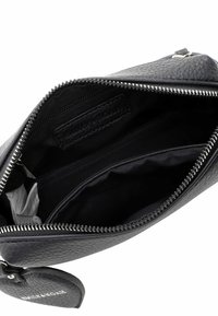 Schwarze Lederetui mit Struktur, offenem silbernem Reißverschluss, der den leeren schwarzen Stoffinnenraum und eine kleine innere Reißverschlusstasche zeigt.