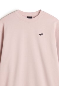Lyserød sweatshirt med rund hals og ribstrikede manchetter. Har et lille sort skateboard-logo på venstre bryst. Blødt stof.