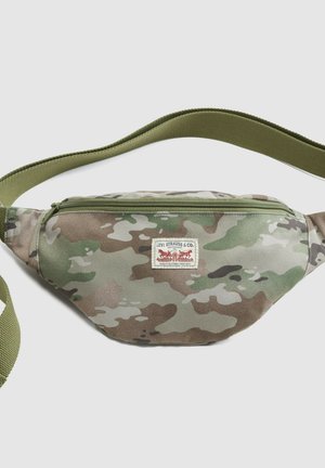 Levi's heuptasje met camouflagepatroon, groene verstelbare riem en ritssluiting, plat gelegd op een lichte achtergrond.