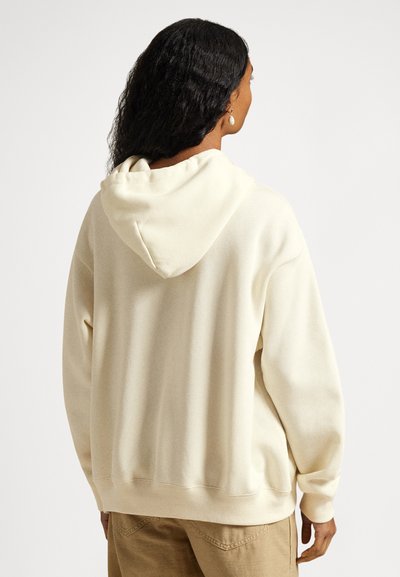 Sweatshirt com capuz de cor creme, com mangas compridas, capuz com cordão e punhos e bainha canelados. Material macio e corte descontraído.