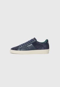 Navy blue sneakers with suede and leather panels, featuring perforated design, flat laces, and a contrasting white rubber sole.