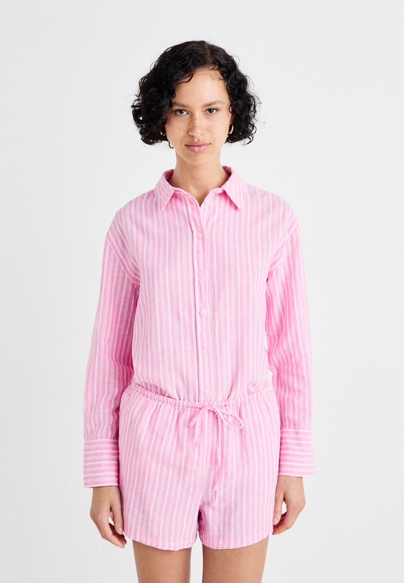 Conjunto de camisa riscada em rosa e calções feito de tecido leve, apresentando botões, um colarinho e uma cintura elástica com detalhe de cordão.