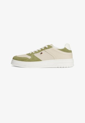 Low-top sneaker met beige leer en olijfgroene suède panelen, witte veters, een merklogo aan de zijkant en een dikke witte rubberen zool.