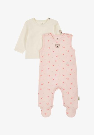 Zwei Babybekleidungsstücke: ein cremefarbener Langarm-Overall mit Schulterknöpfen und ein rosa Fußsack mit Blumendruck und Teddybär-Aufnäher.